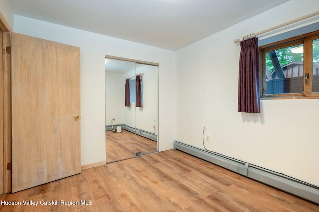 59 Mountain Dr, Hunter, NY 12442 - unfurnished bedroom with a baseboard heating unit, wood finished floors, and a closet