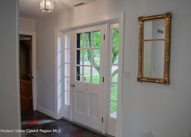 foyer entrance featuring crown molding and a chandelier