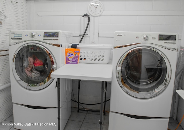 laundry area featuring independent washer and dryer and light tile patterned floors