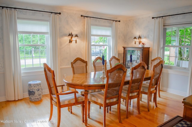 dining area featuring a healthy amount of sunlight, light hardwood / wood-style floors, and crown molding