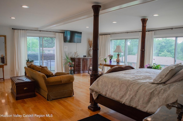 bedroom featuring access to outside, multiple windows, and light wood-type flooring