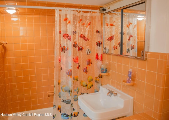 bathroom with sink and tile walls