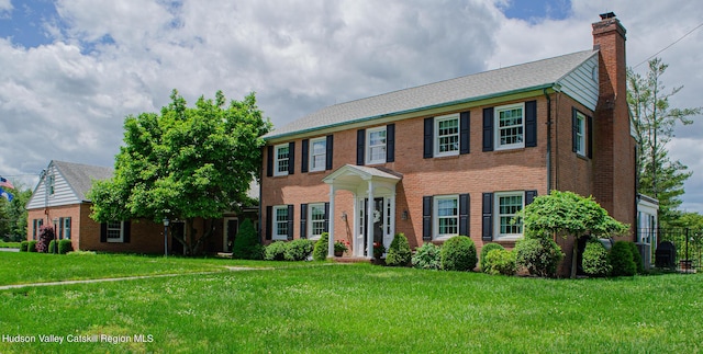 colonial house featuring a front yard