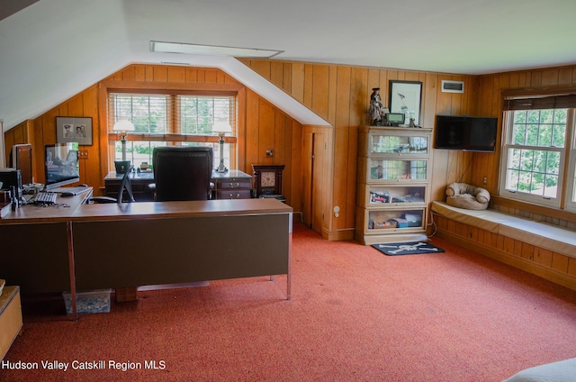 home office with carpet flooring, lofted ceiling, wooden walls, and a healthy amount of sunlight