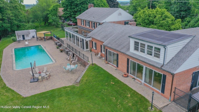 view of swimming pool featuring a patio area, an outbuilding, and a yard