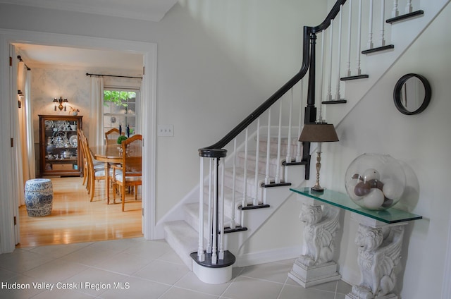 stairs with crown molding and wood-type flooring