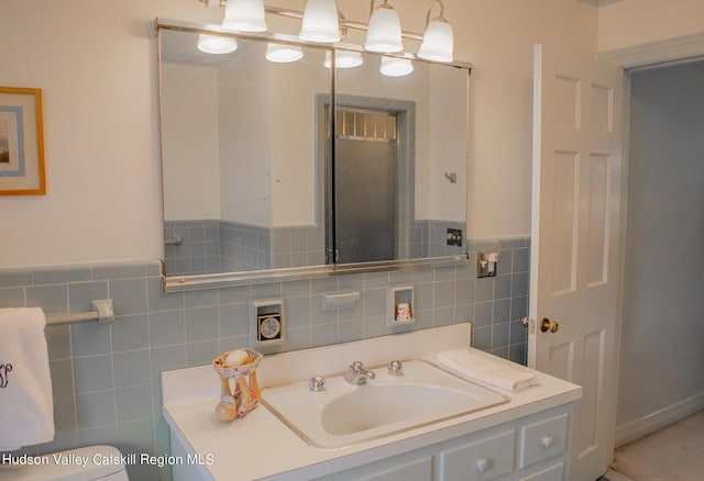 bathroom featuring vanity, tile walls, and toilet