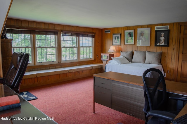 carpeted bedroom featuring wood walls