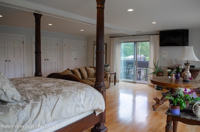 bedroom featuring access to exterior, decorative columns, ornamental molding, light hardwood / wood-style floors, and multiple closets