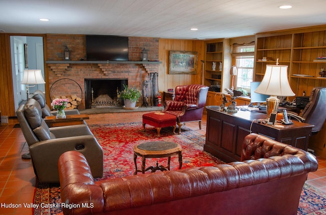 living room with tile patterned flooring, a brick fireplace, built in features, and wooden walls