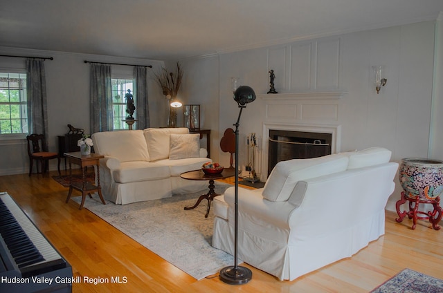 living room with wood-type flooring, plenty of natural light, and crown molding