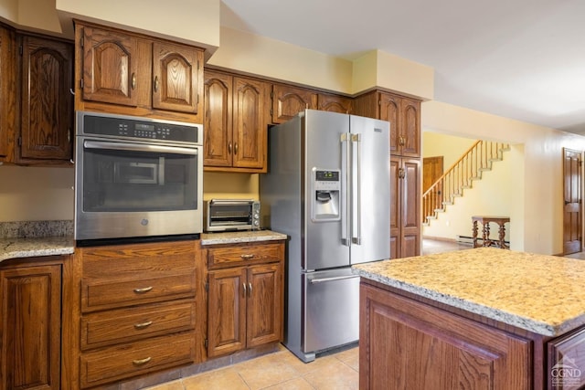 213 Botti Dr, Hunter, NY 12442 - kitchen with stainless steel appliances, light tile patterned flooring, light stone counters, and brown cabinetry