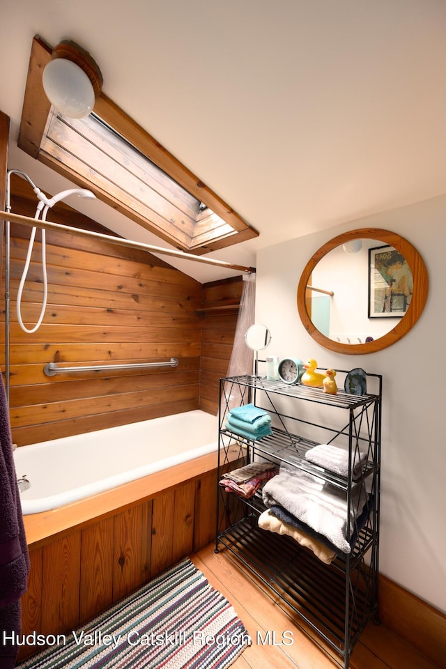 159 Pine Ln, Saugerties, NY 12477 - bathroom featuring wood walls, a skylight, and wood finished floors