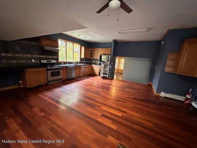 kitchen featuring appliances with stainless steel finishes, dark hardwood / wood-style flooring, tasteful backsplash, and ceiling fan