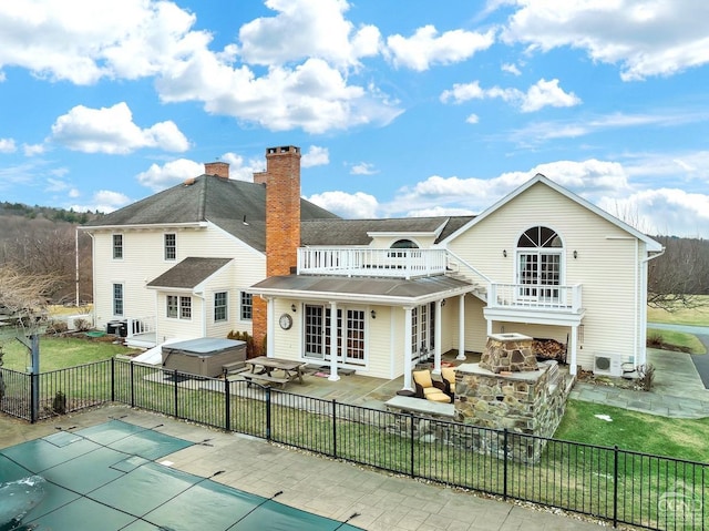 311 County Route 13, Old Chatham, NY 12136 - rear view of house with a hot tub, french doors, a balcony, a patio, and a chimney