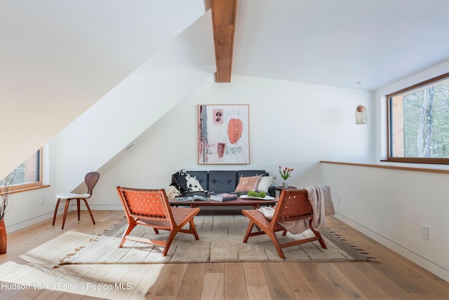 living room with vaulted ceiling with beams, wood-type flooring, and baseboards