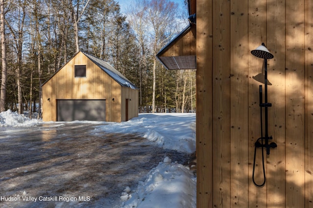 snow covered garage with a detached garage