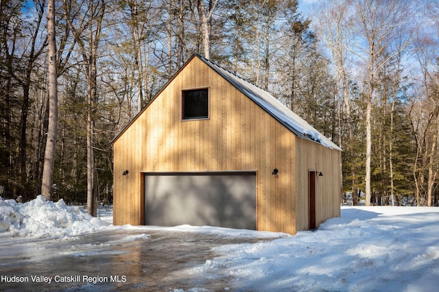 snow covered garage with a garage