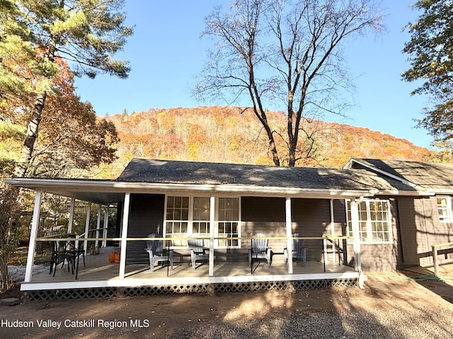 rear view of property with a deck with mountain view