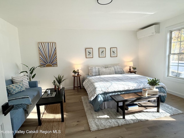 bedroom with a wall unit AC and hardwood / wood-style flooring