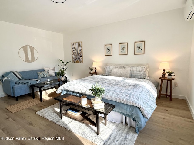 bedroom featuring an AC wall unit and hardwood / wood-style flooring