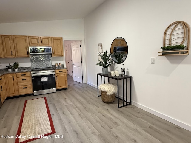 kitchen with decorative backsplash, high vaulted ceiling, stainless steel appliances, and light wood-type flooring