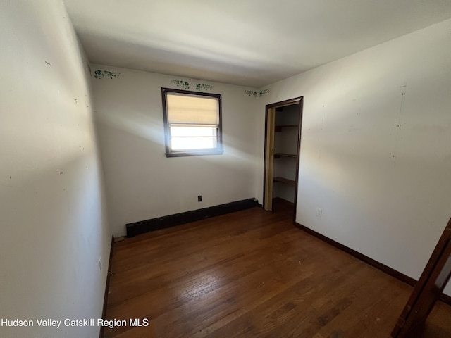 empty room with dark hardwood / wood-style flooring