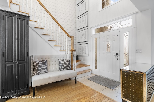 foyer with a high ceiling and light hardwood / wood-style floors