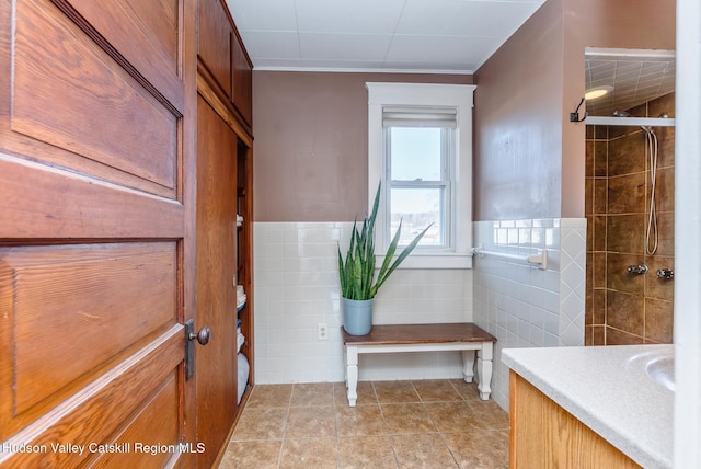 bathroom with vanity, tile walls, tile patterned floors, and tiled shower