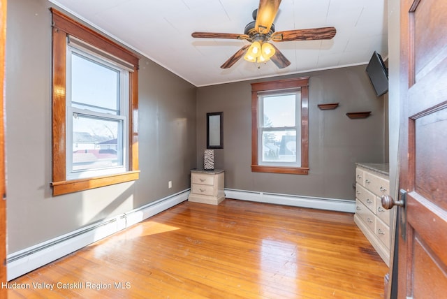 unfurnished bedroom with baseboards, light wood-type flooring, baseboard heating, and ornamental molding