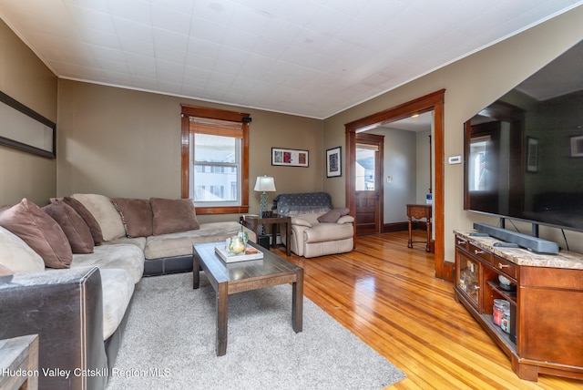 living room with baseboards, a healthy amount of sunlight, and light wood-style flooring