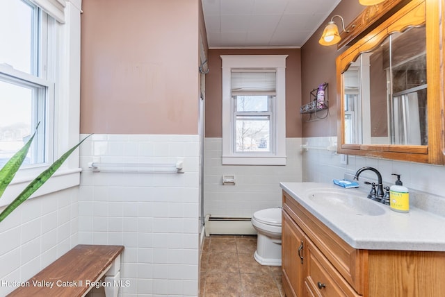 full bathroom with wainscoting, toilet, vanity, and a baseboard heating unit