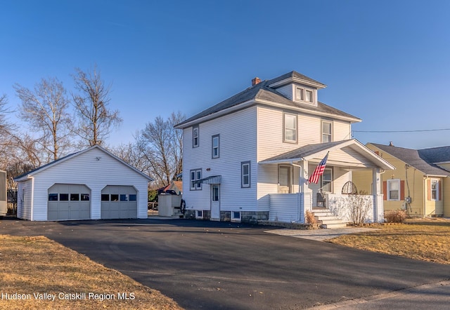 view of front of home with a chimney, a detached garage, and an outdoor structure