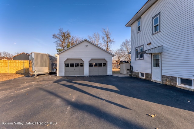 view of home's exterior with an outbuilding, fence, and a garage