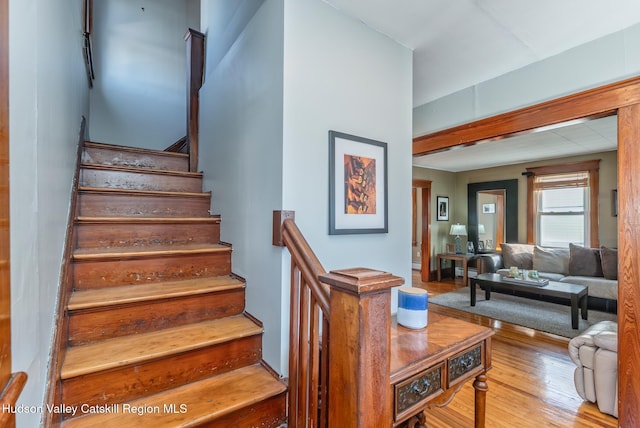 staircase with wood finished floors and a baseboard radiator