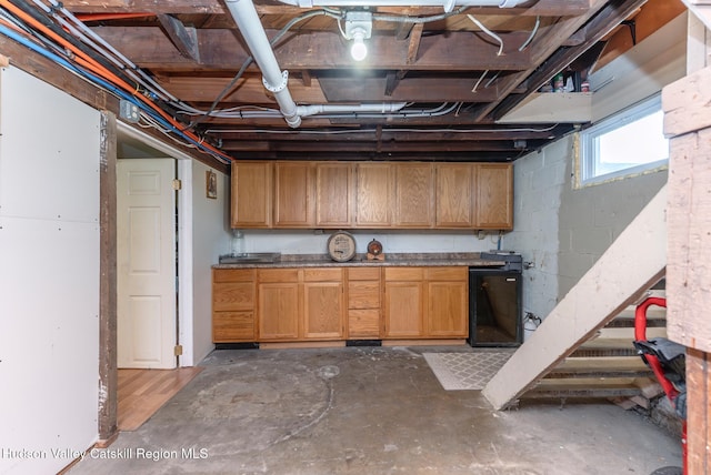 basement with concrete block wall and fridge