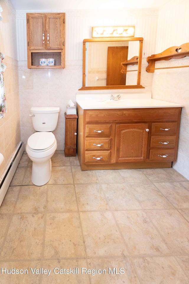 55 Harry Wells Rd, Saugerties, NY 12477 - half bathroom with tile walls, toilet, vanity, and a baseboard radiator