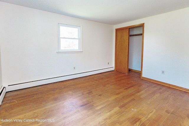 55 Harry Wells Rd, Saugerties, NY 12477 - unfurnished bedroom with a baseboard heating unit, light wood finished floors, baseboards, and a closet