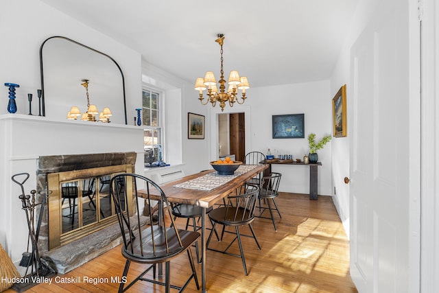 660-668 N Chodikee Lake Rd, Highland, NY 12528 - dining room with a chandelier, wood finished floors, a multi sided fireplace, and baseboards