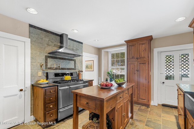 660-668 N Chodikee Lake Rd, Highland, NY 12528 - kitchen with range with two ovens, wall chimney range hood, recessed lighting, brown cabinetry, and butcher block counters
