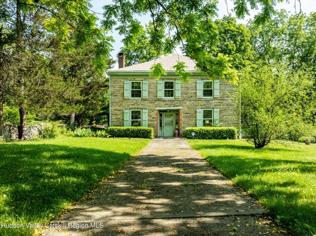 660-668 N Chodikee Lake Rd, Highland, NY 12528 - colonial home featuring stone siding, a chimney, and a front lawn