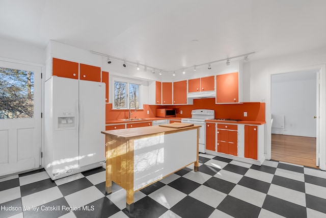 660-668 N Chodikee Lake Rd, Highland, NY 12528 - kitchen featuring white appliances, under cabinet range hood, a sink, tile patterned floors, and rail lighting