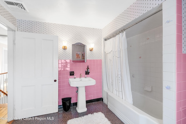 660-668 N Chodikee Lake Rd, Highland, NY 12528 - bathroom featuring wallpapered walls, tile walls, shower / bathtub combination with curtain, and a wainscoted wall