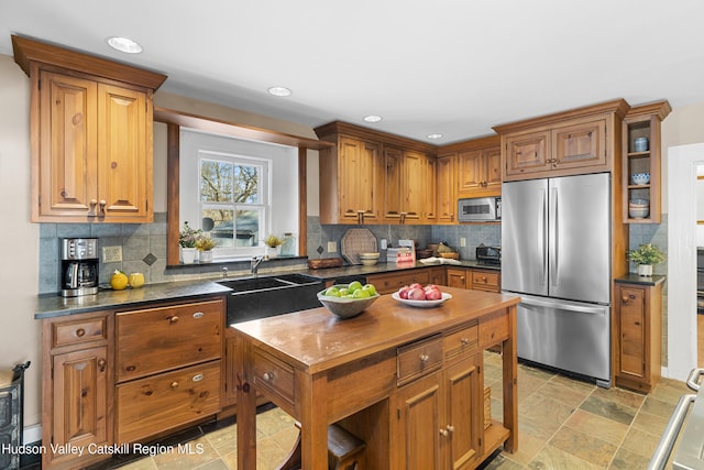 660-668 N Chodikee Lake Rd, Highland, NY 12528 - kitchen with appliances with stainless steel finishes, brown cabinets, a sink, decorative backsplash, and recessed lighting