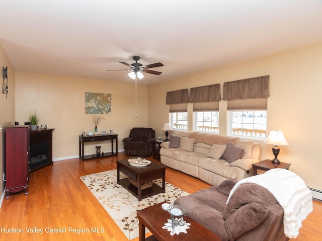 living room with light hardwood / wood-style flooring and ceiling fan