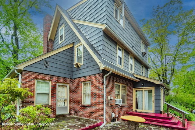 38 Plattekill Ave, New Paltz, NY 12561 - view of home's exterior with a chimney, brick siding, cooling unit, and a patio