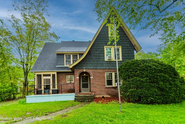 38 Plattekill Ave, New Paltz, NY 12561 - tudor-style house with a front lawn, cooling unit, and brick siding