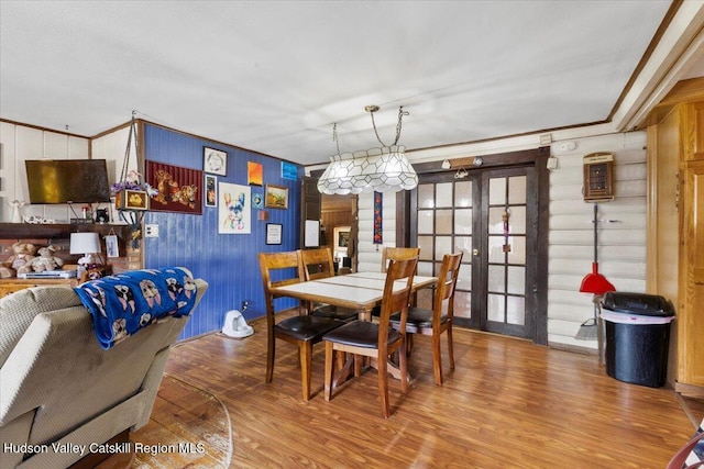 dining room featuring wood-type flooring, french doors, and ornamental molding