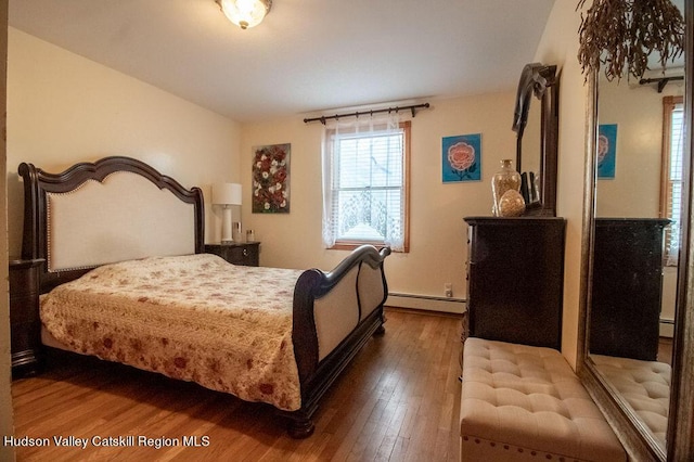 bedroom with wood-type flooring and baseboard heating