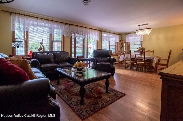 living room with hardwood / wood-style floors and an inviting chandelier